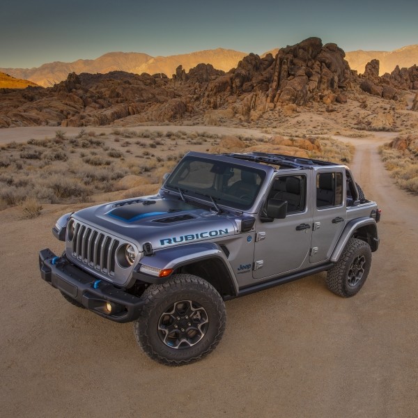 Logo du Jeep 4xe 2021 devant un arrière-plan pittoresque formé de montagnes et d’un lac.