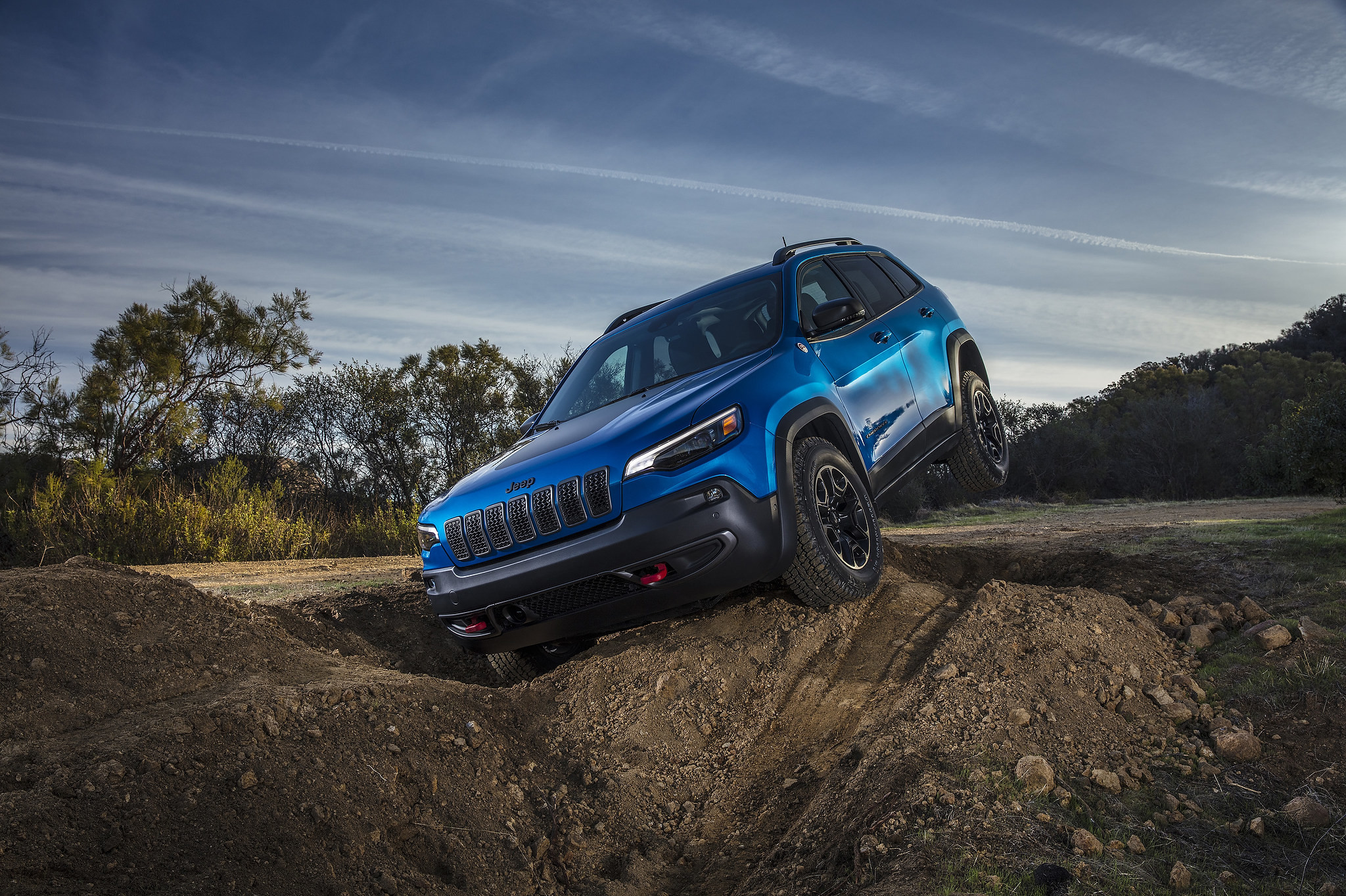 Un Jeep Cherokee Trailhawk 2021 garé sur un monticule de terre avec les roues arrière qui ne touche pas au sol