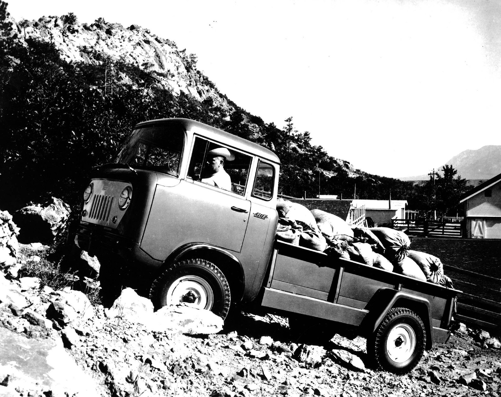 Un Jeep FC-170 1957 avec une boite remplie dans une pente rocheuse