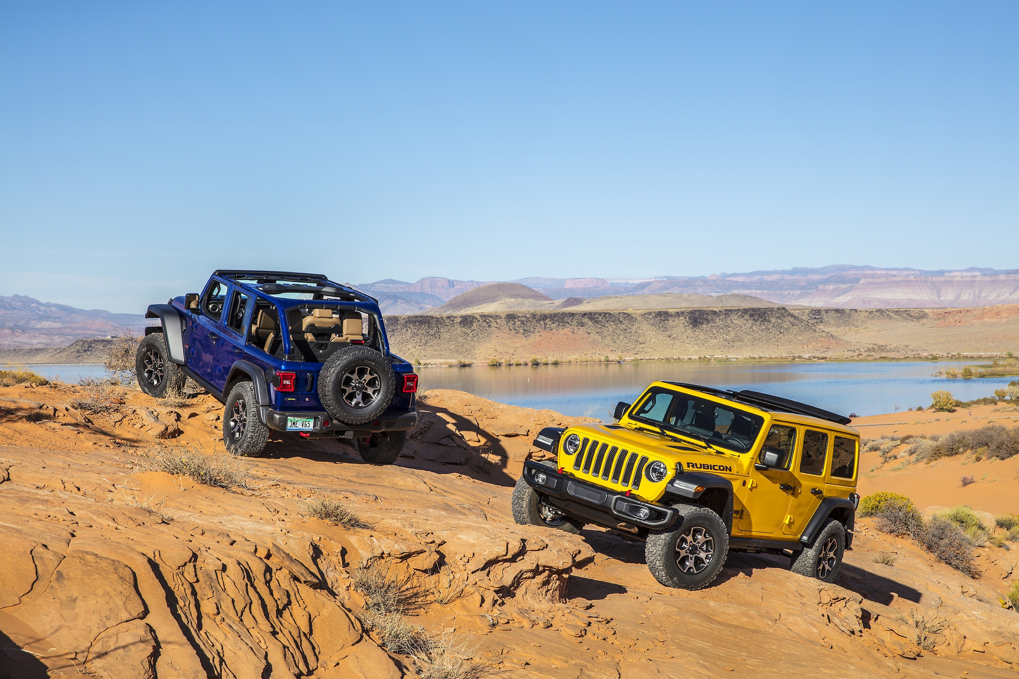 Two 2021 Jeep Wrangler Rubicon EcoDiesel parked on top of a rocky slope overseeing a lake and mountains