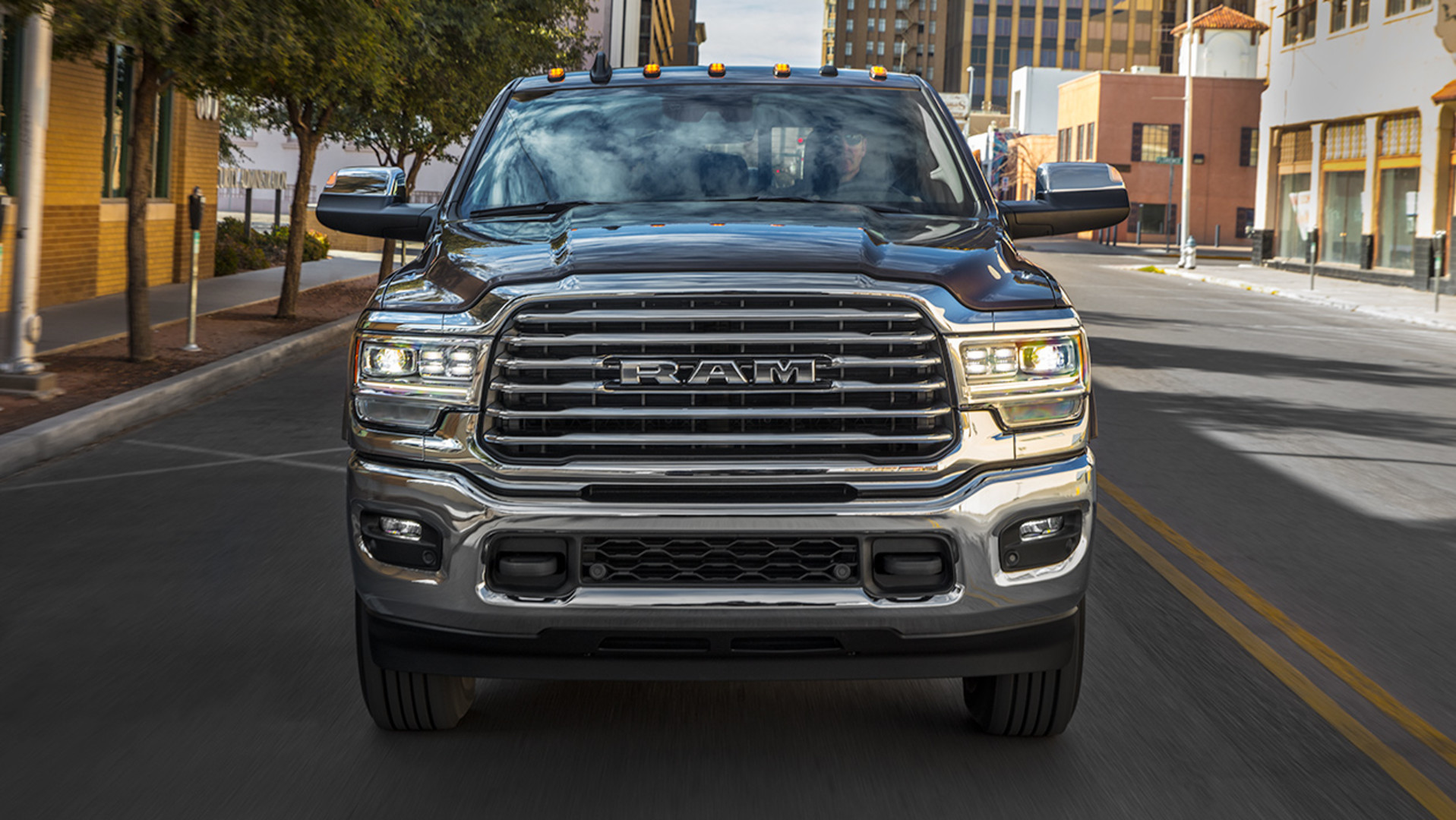 Front view of black the new 2019 Ram HD pickup truck being driven on a city road
