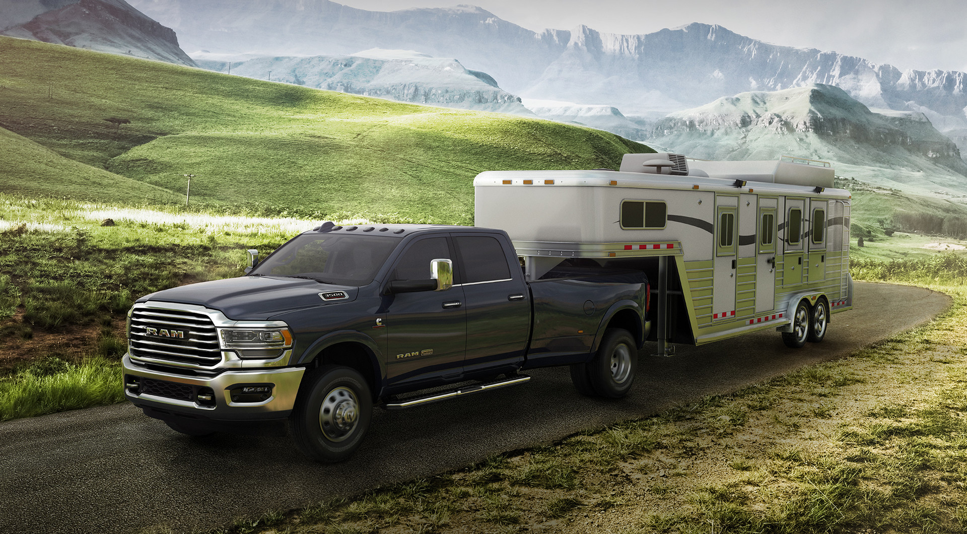 Front three quarter view of Black 2019 Ram HD pickup Truck Towing a White Trailer Through the Mountains
