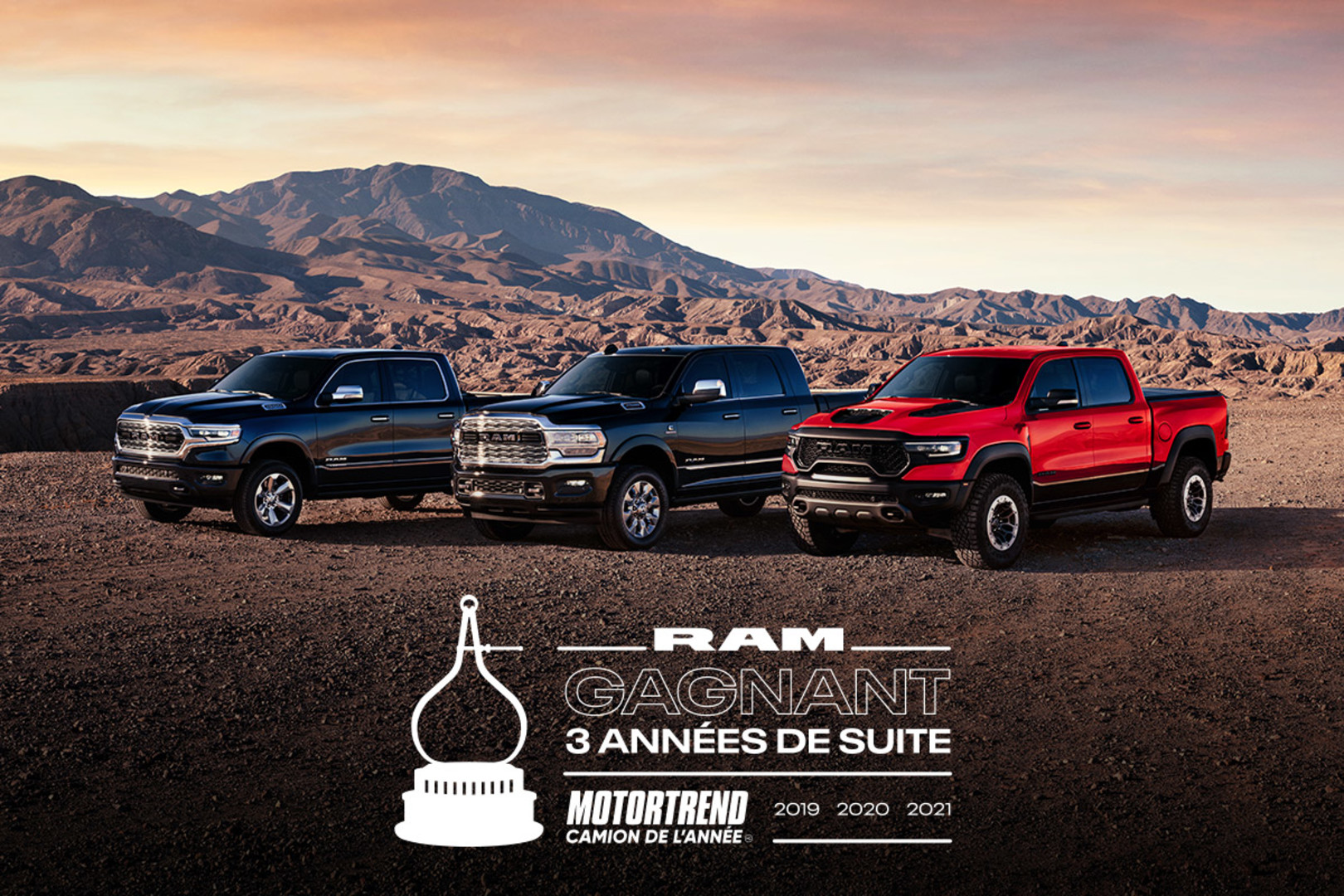 Gamme de trois camions Ram dans un désert rocheux entouré d’une chaîne de montagnes. Trois fois au sommet du palmarès : le Ram a été déclaré Camion de l’année selon MotorTrend en 2019, 2020 et 2021.