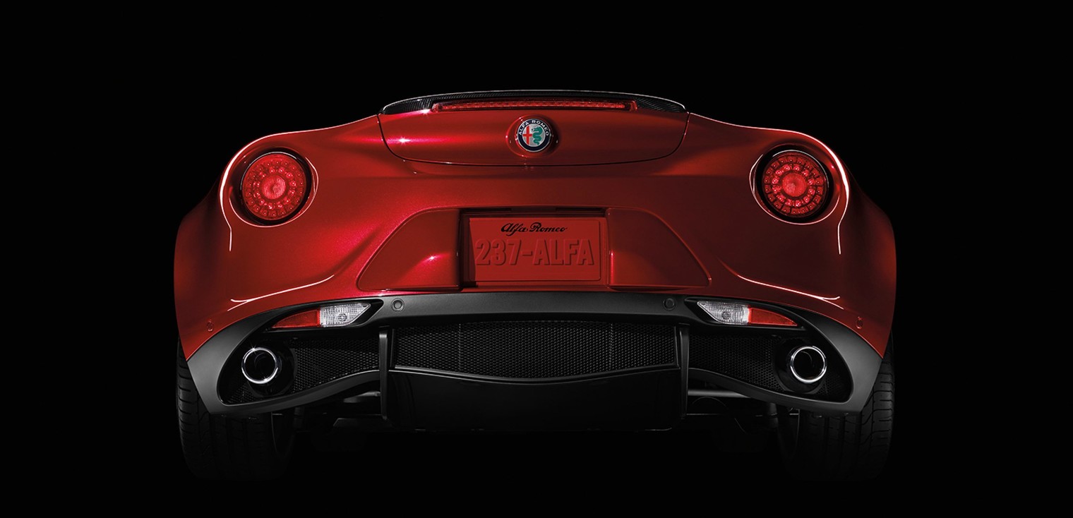 Vue arrière de l’Alfa Romeo 4C Spider 2019, illustré en rouge, garée dans un studio sombre