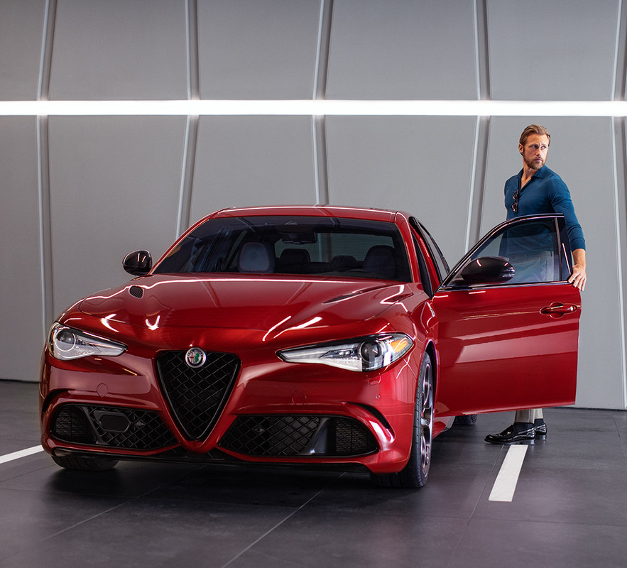Man entering driver side of Red 2020 Alfa Romeo Giulia