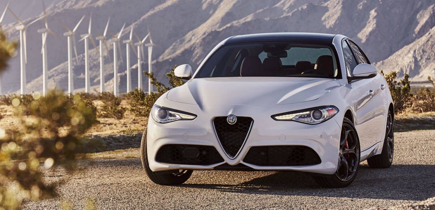 Front view of the white 2019 Alfa Romeo Giulia parked on a street in front of a mountain