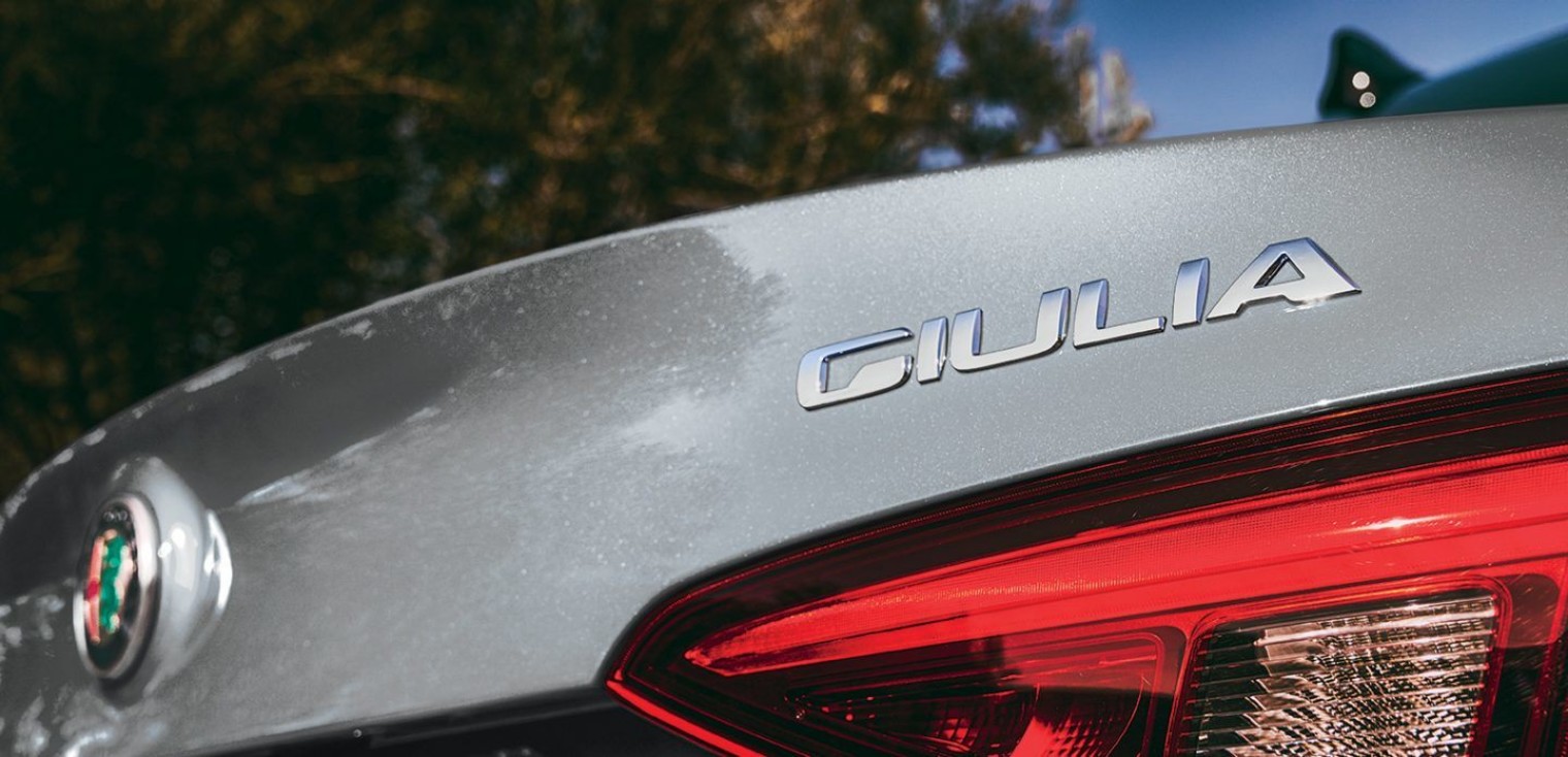 Close up view of the badge and a tail light on the silver 2019 Alfa Romeo Giulia