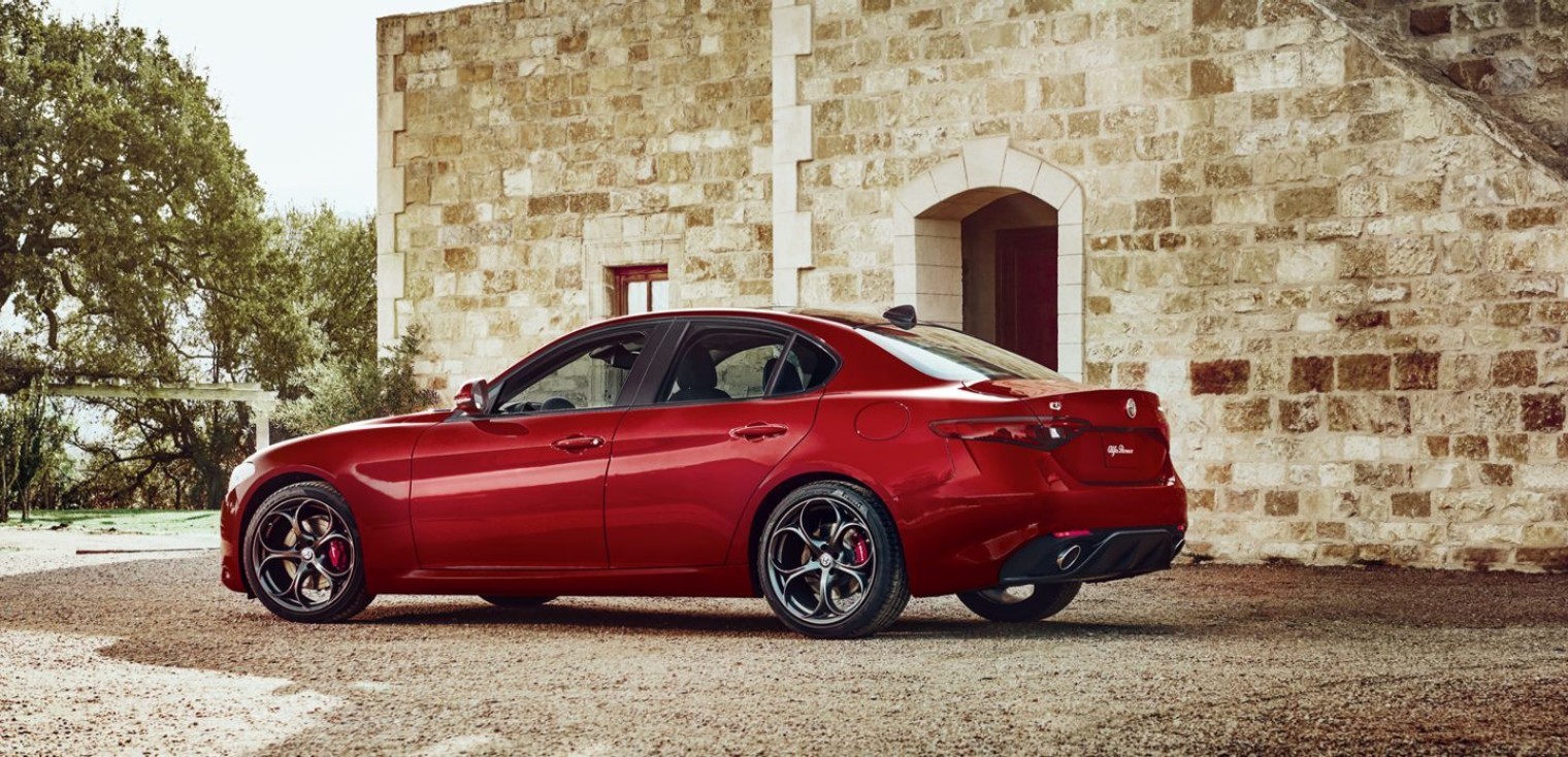 Side view of the red 2019 Alfa Romeo Giulia parked outside, beside a building