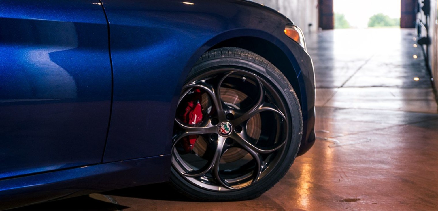 The Y-spoke aluminum wheels of the blue 2019 Alfa Romeo Giulia