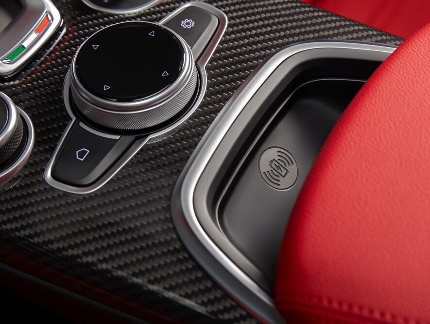 A close-up of the shifter, seat controls and wireless charging pocket in the centre console of the 2020 Alfa Romeo Giulia.