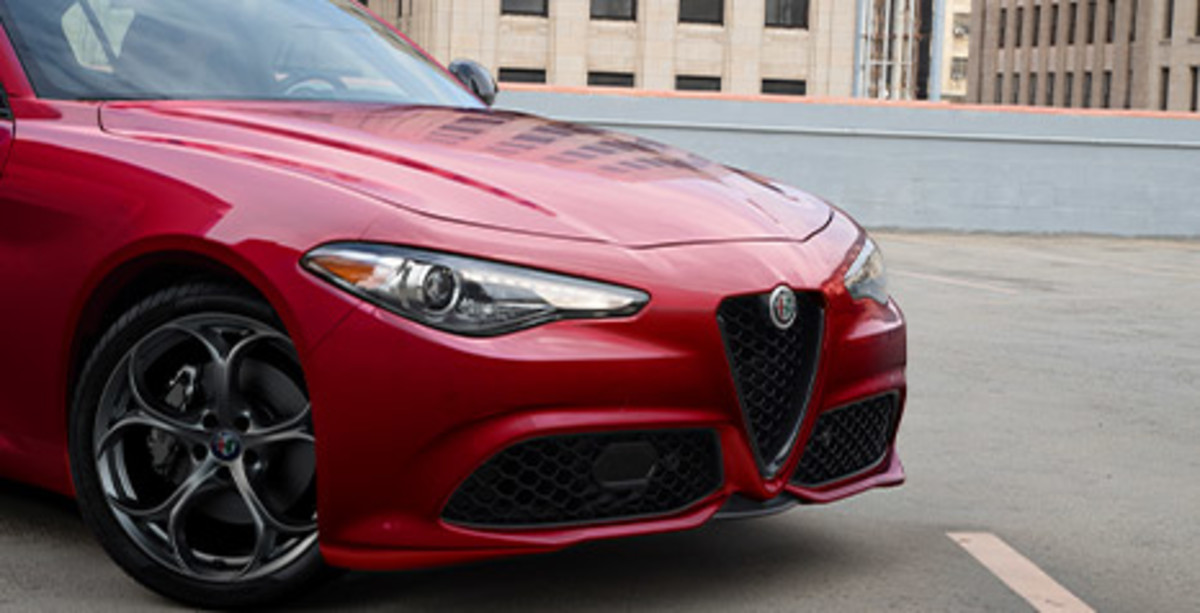Front quarter view of a red Alfa Romeo Giulia, parked in a parking lot