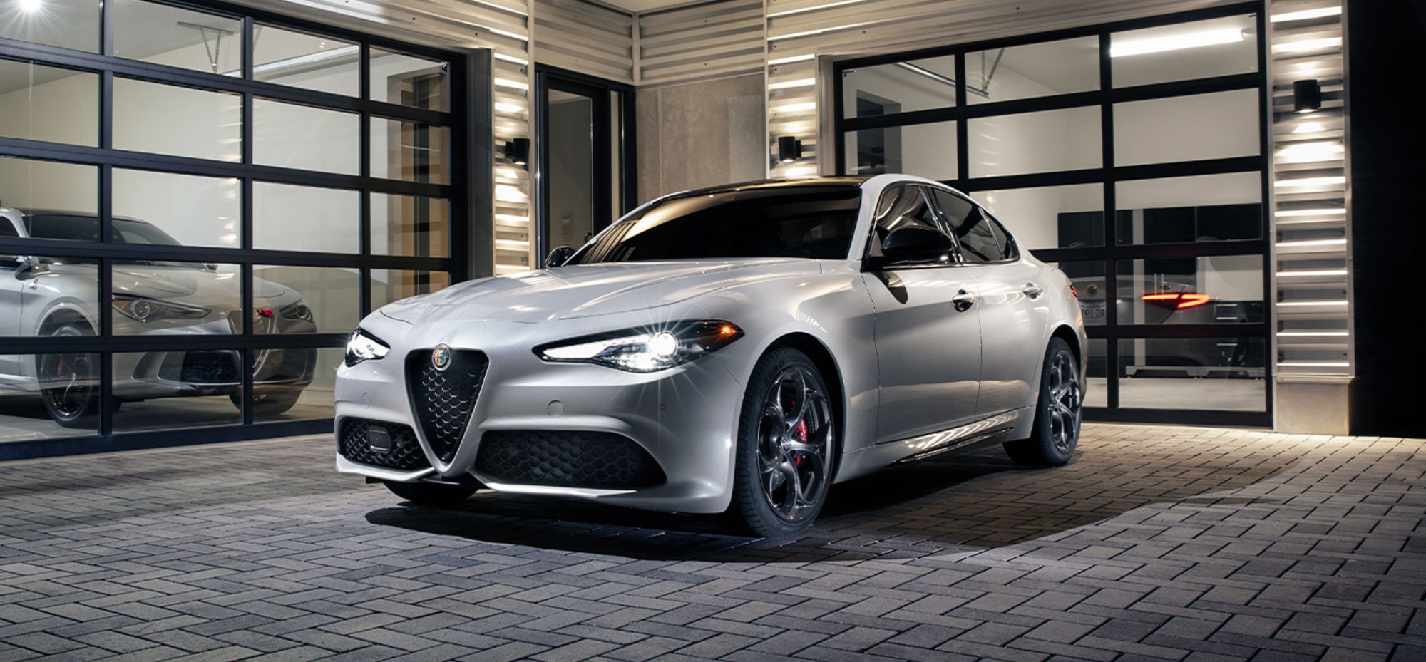 Front quarter view of a silver Alfa Romeo Giulia, parked in a driveway
