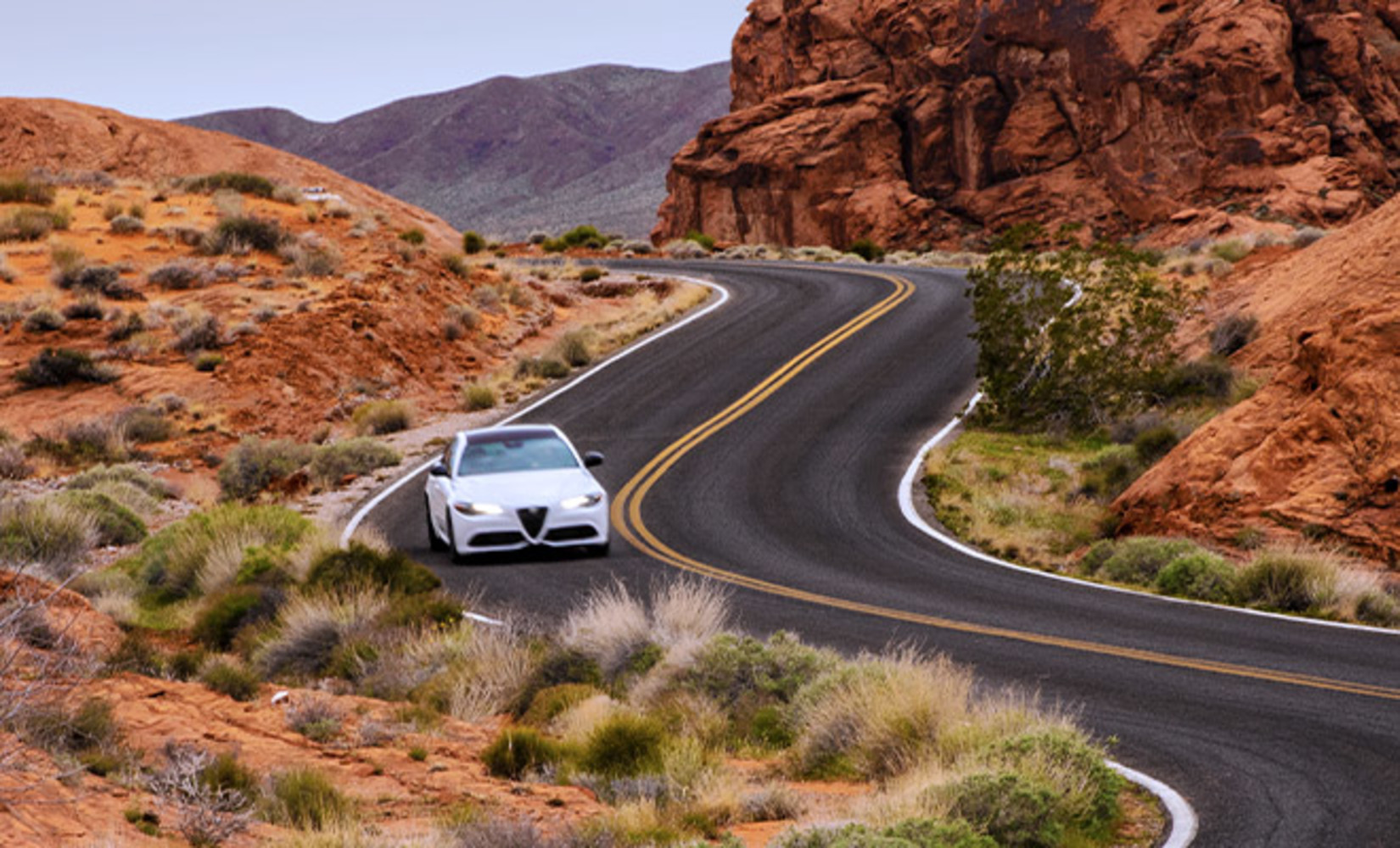 View of a white 2021 Alfa Romeo Giulia 2021, being driven on a road in the mountains