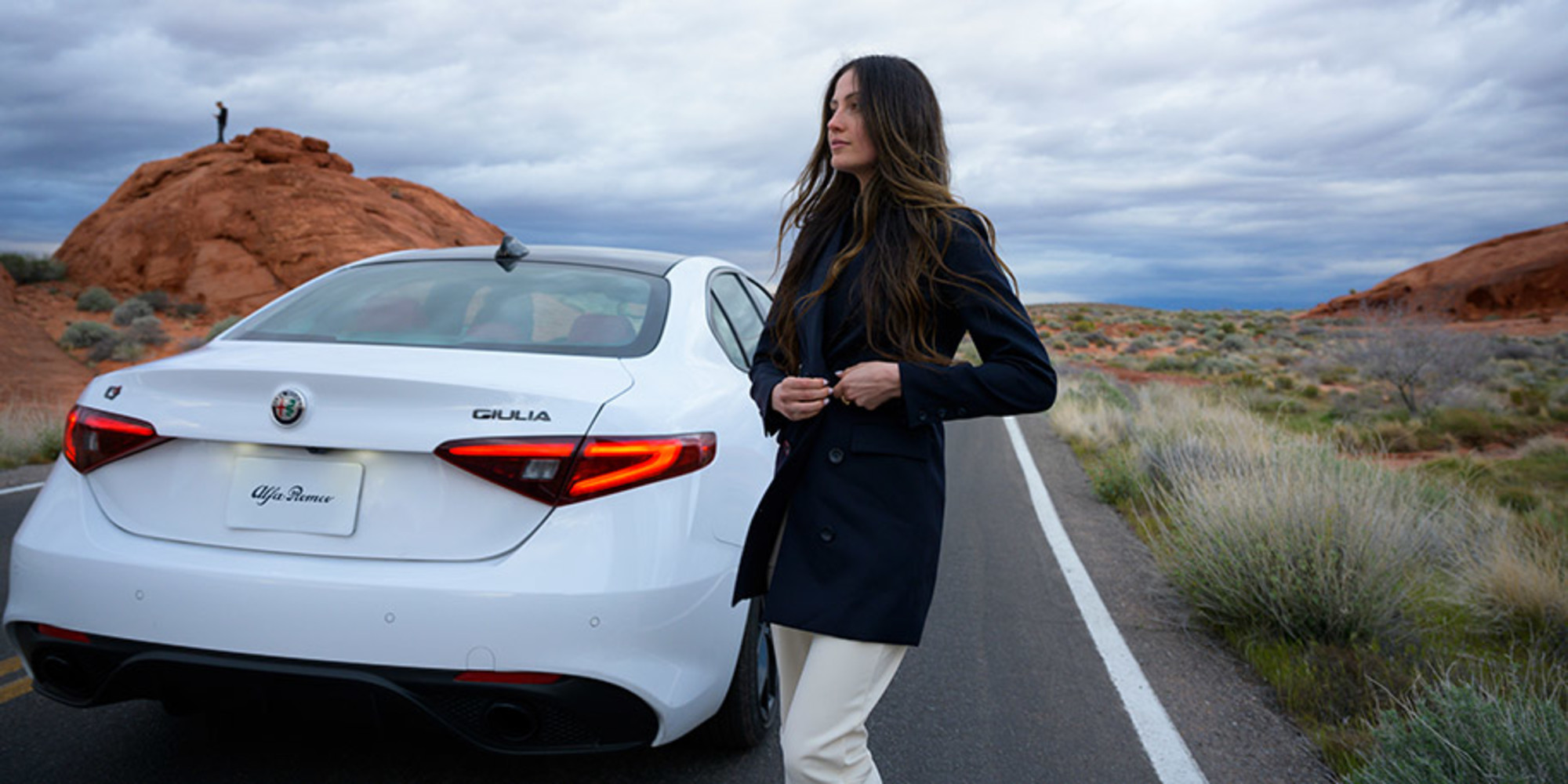 Woman standing next to White 2021 Alfa Romeo Giulia