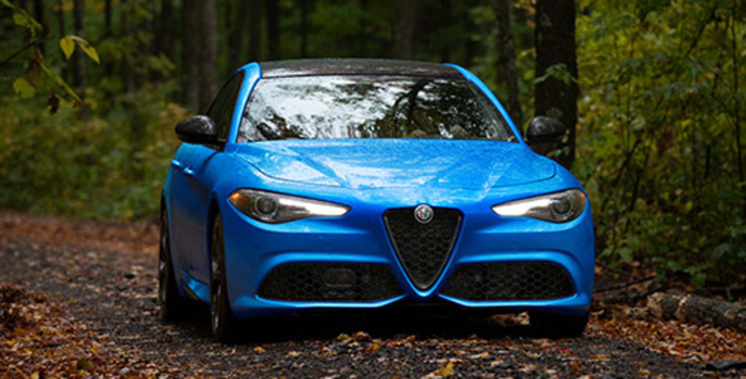 Blue 2021 Alfa Romeo Giulia being driven through the forest