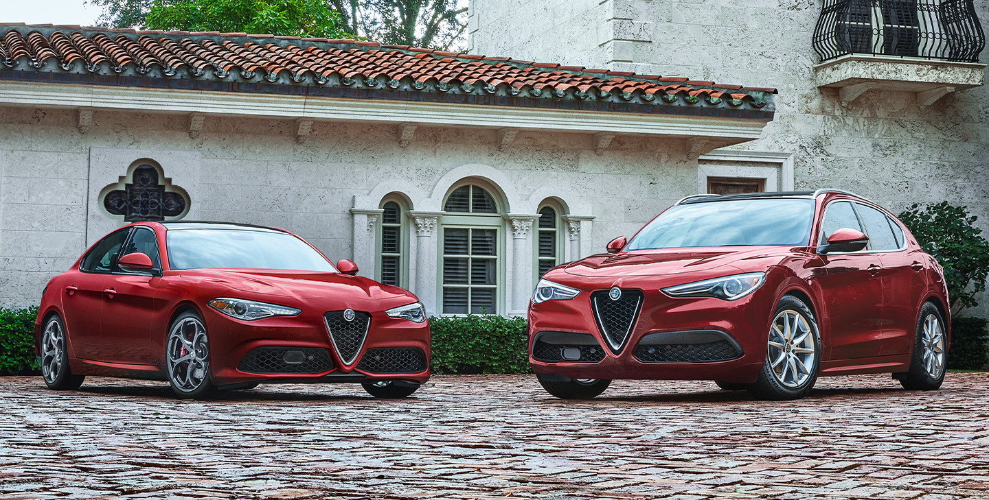 Les modèles Alfa Romeo Giulia et Stelvio, illustrés en rouge, stationnés dans une entrée devant un manoir