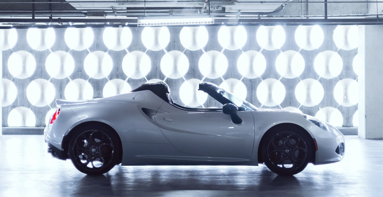 Alfa Romeo 4C Spider side profile with white exterior in a studio