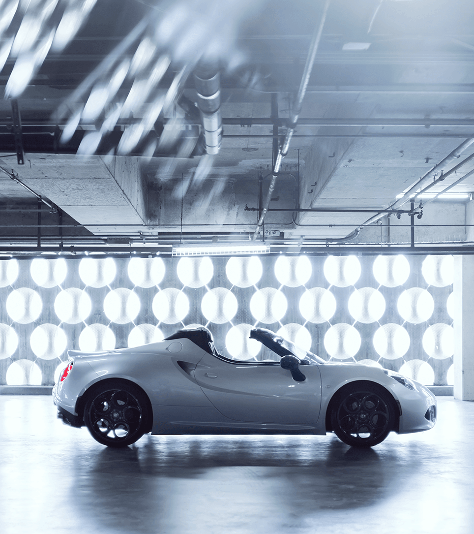 Alfa Romeo 4C Spider side profile with white exterior in a studio