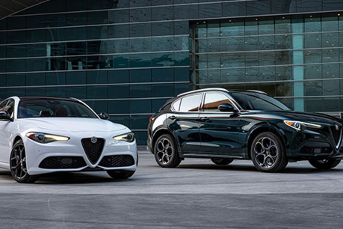 Une Alfa Romeo Giulia blanche et une Alfa Romeo Stelvio verte garées devant un grand bâtiment en verre.