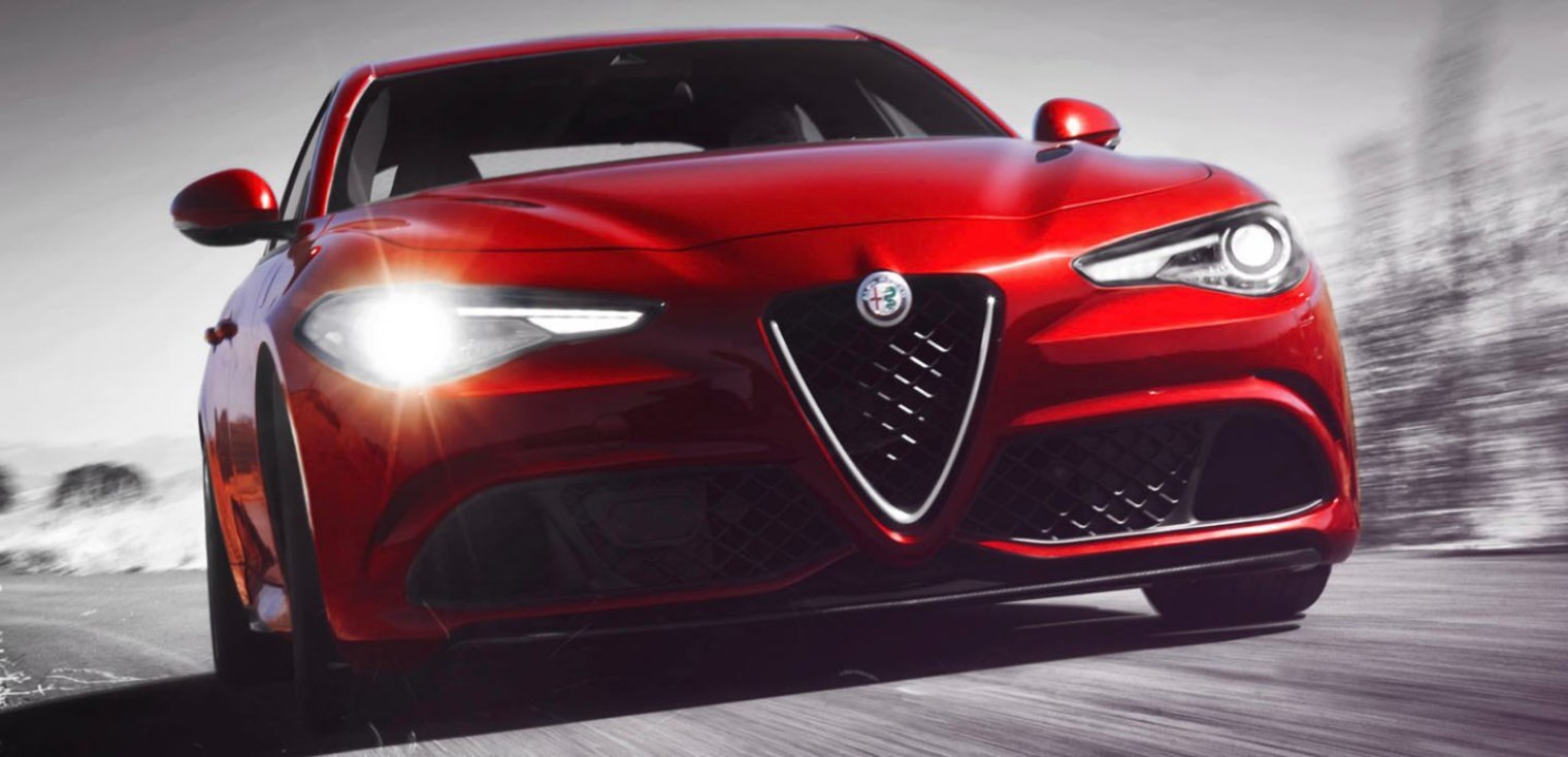 Front view of the red 2019 Alfa Romeo Giulia Quadrifoglio driving down a street in an urban area