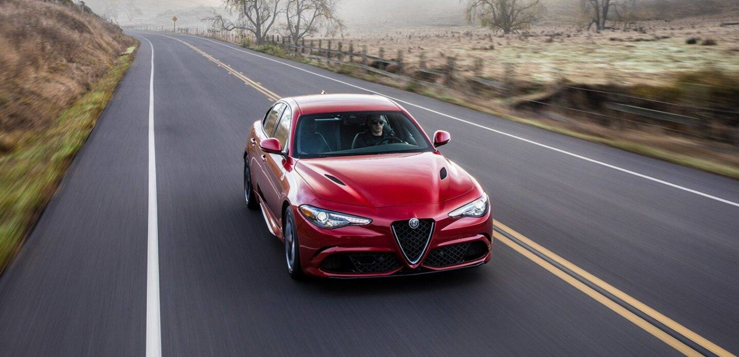 Front view of the red 2019 Alfa Romeo Quadrifoglio driving down a country road