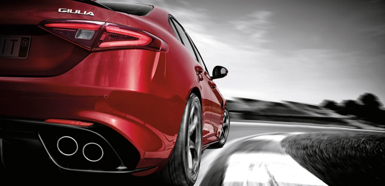Rear view of the red 2019 Alfa Romeo Quadrifoglio being driven on a race track