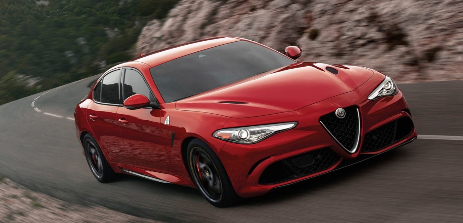 Front view of the red 2019 Alfa Romeo Giulia Quadrifoglio driving down a road in the mountains