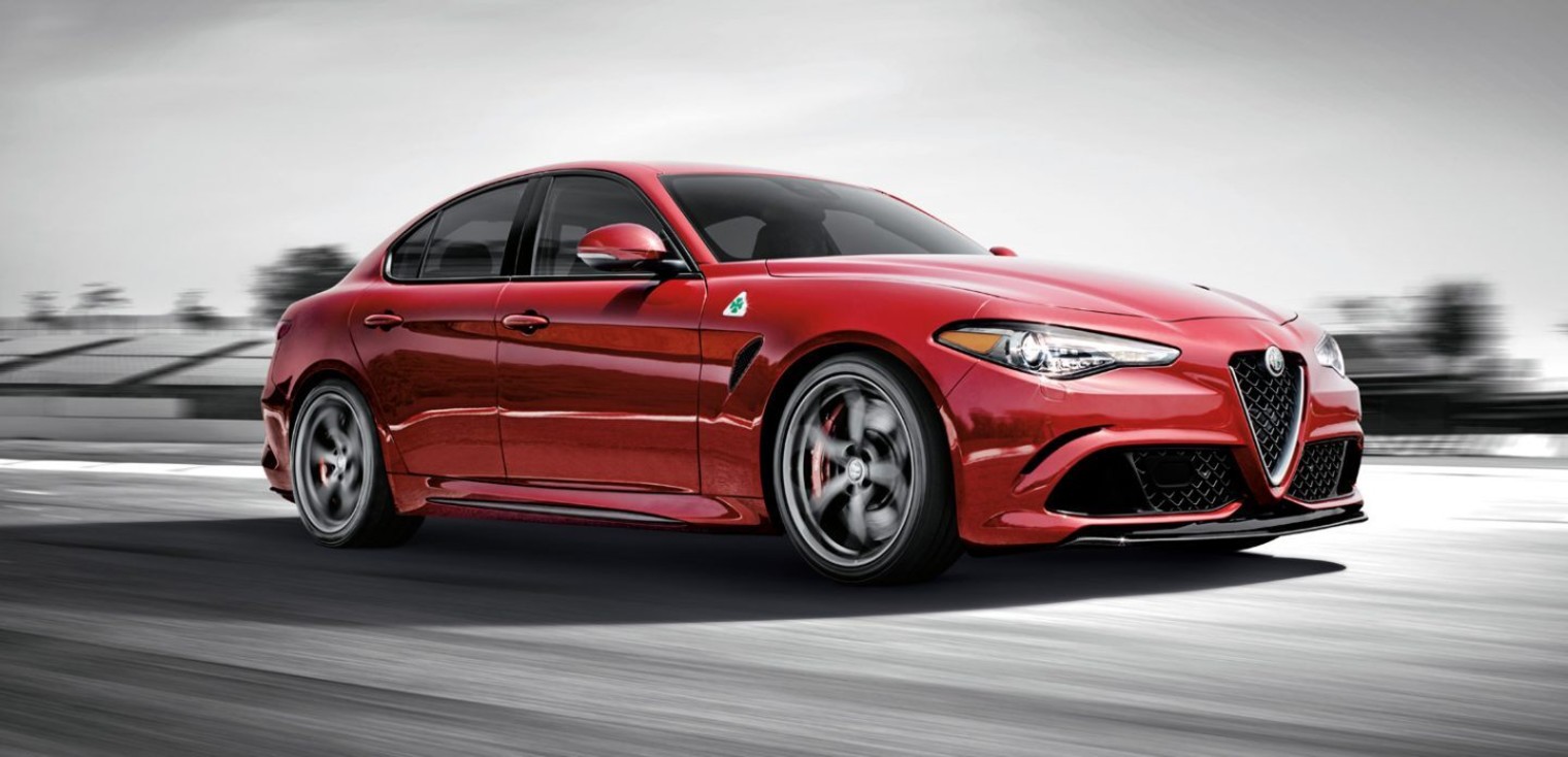 Side view of the red 2019 Alfa Romeo Giulia Quadrifoglio being driven on a race track