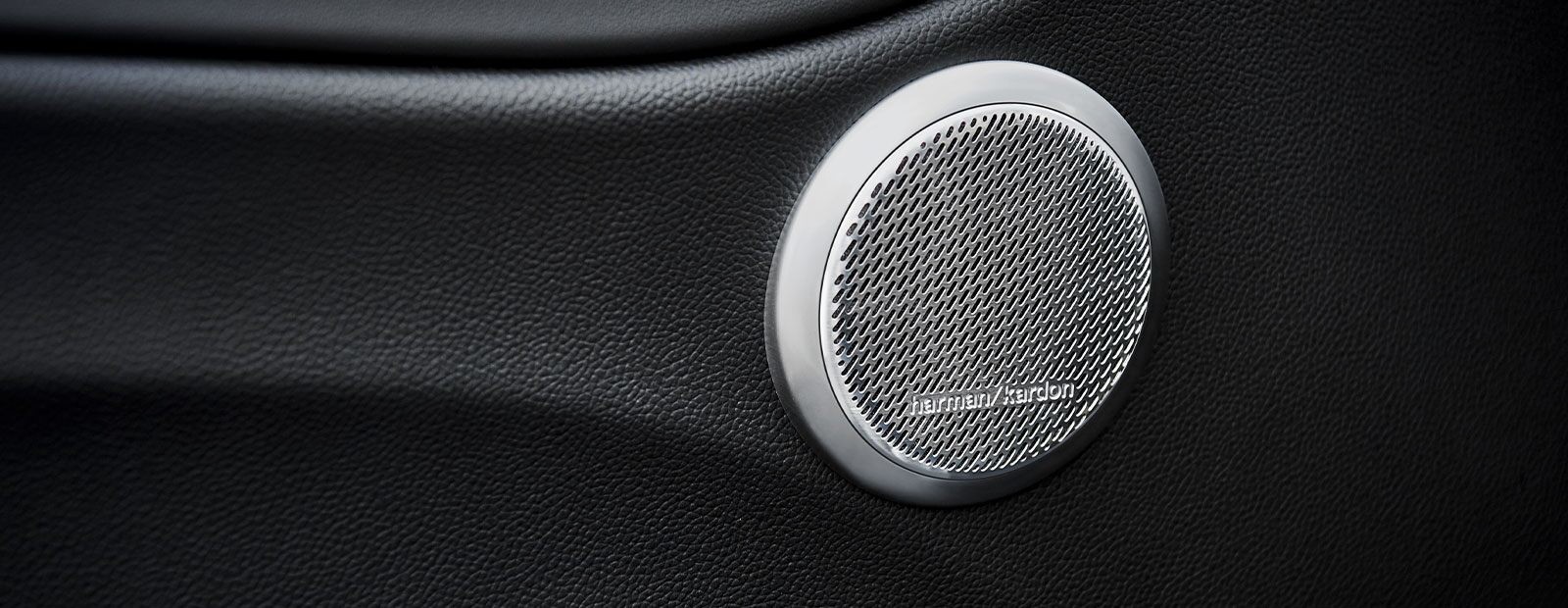 A close-up of a Harman Kardon speaker in the door panel of the 2021 Alfa Romeo Giulia Quadrifoglio.