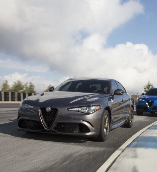 The 2021 Alfa Romeo Giulia Quadrifoglio in grey racing on a track.