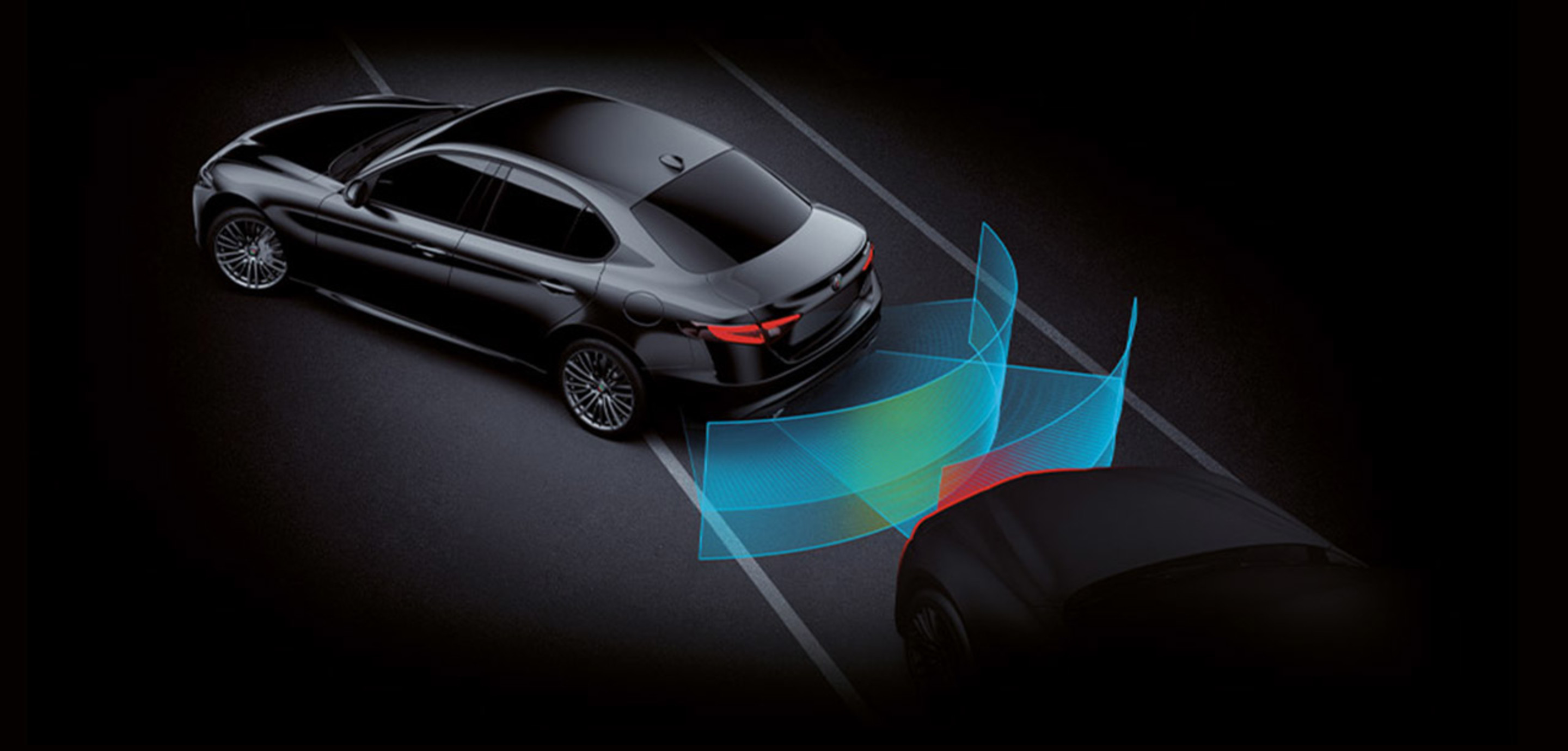 Night view of black 2023 Alfa Romeo Giulia Quadrifoglio with blind spot monitoring activated.