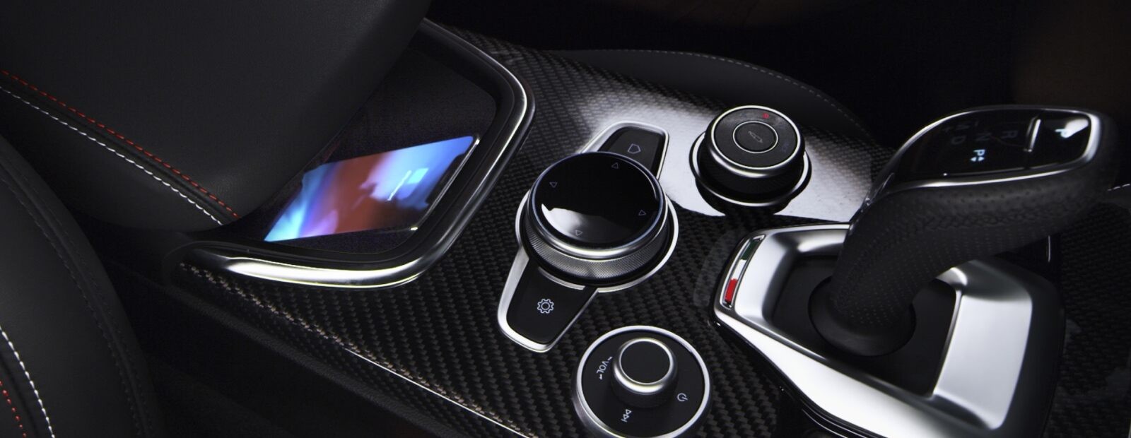 Un gros plan sur la pochette de recharge sans fil dans la console centrale de l’Alfa Romeo Stelvio Quadrifoglio 2021.