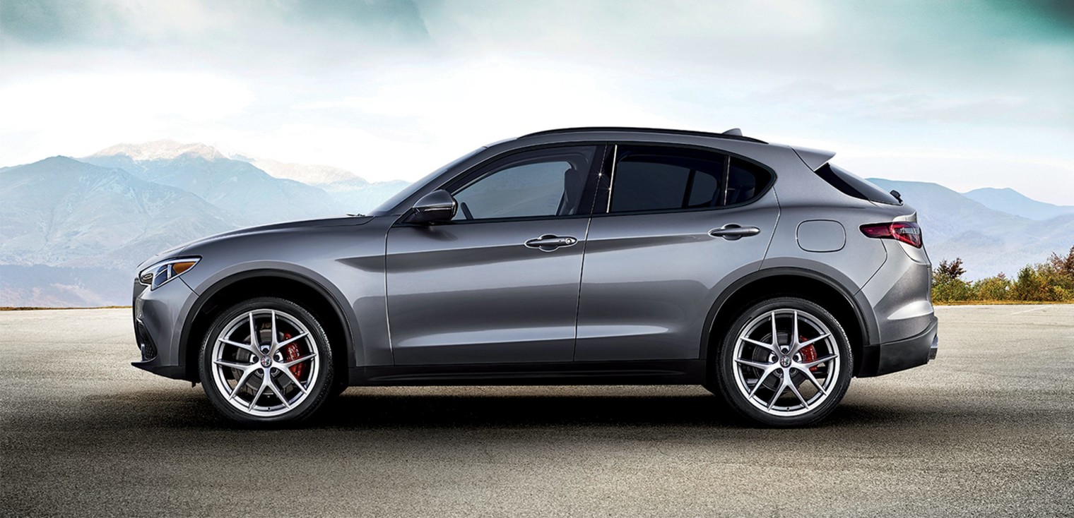 Vue latérale de l’Alfa Romeo Stelvio 2019, illustré en argent, stationné dans les montagnes