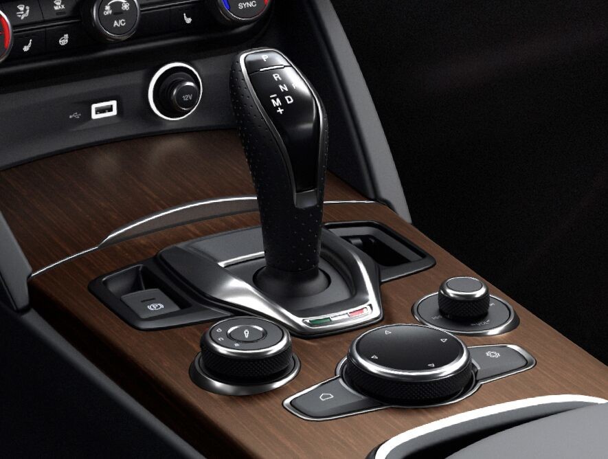 A close-up of the centre console in the 2020 Alfa Romeo Stelvio focusing on the shifter and seat controls.