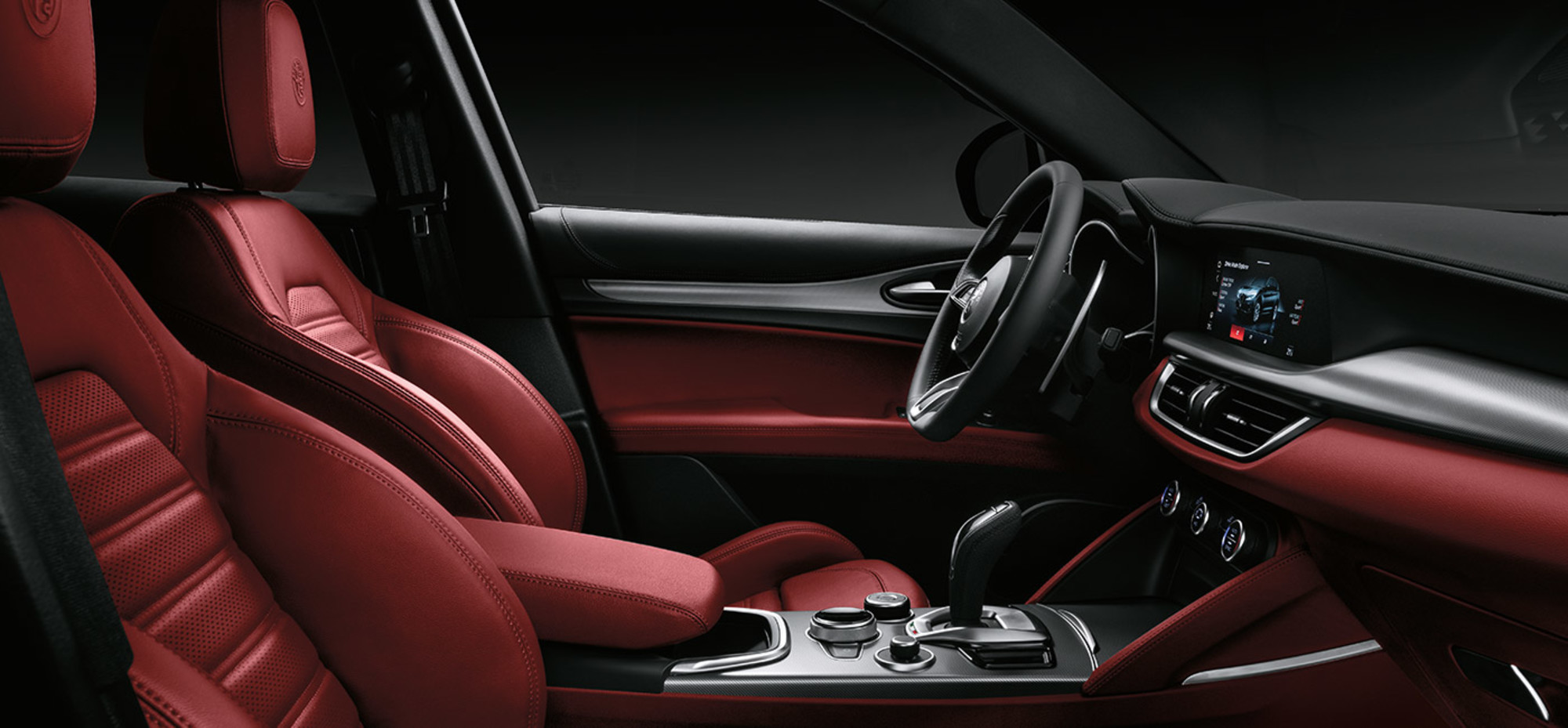 A close-up of the leather-wrapped steering wheel, wood-trimmed console and Crema leather power front seats inside the elegant cabin of the 2021 Alfa Romeo Stelvio.