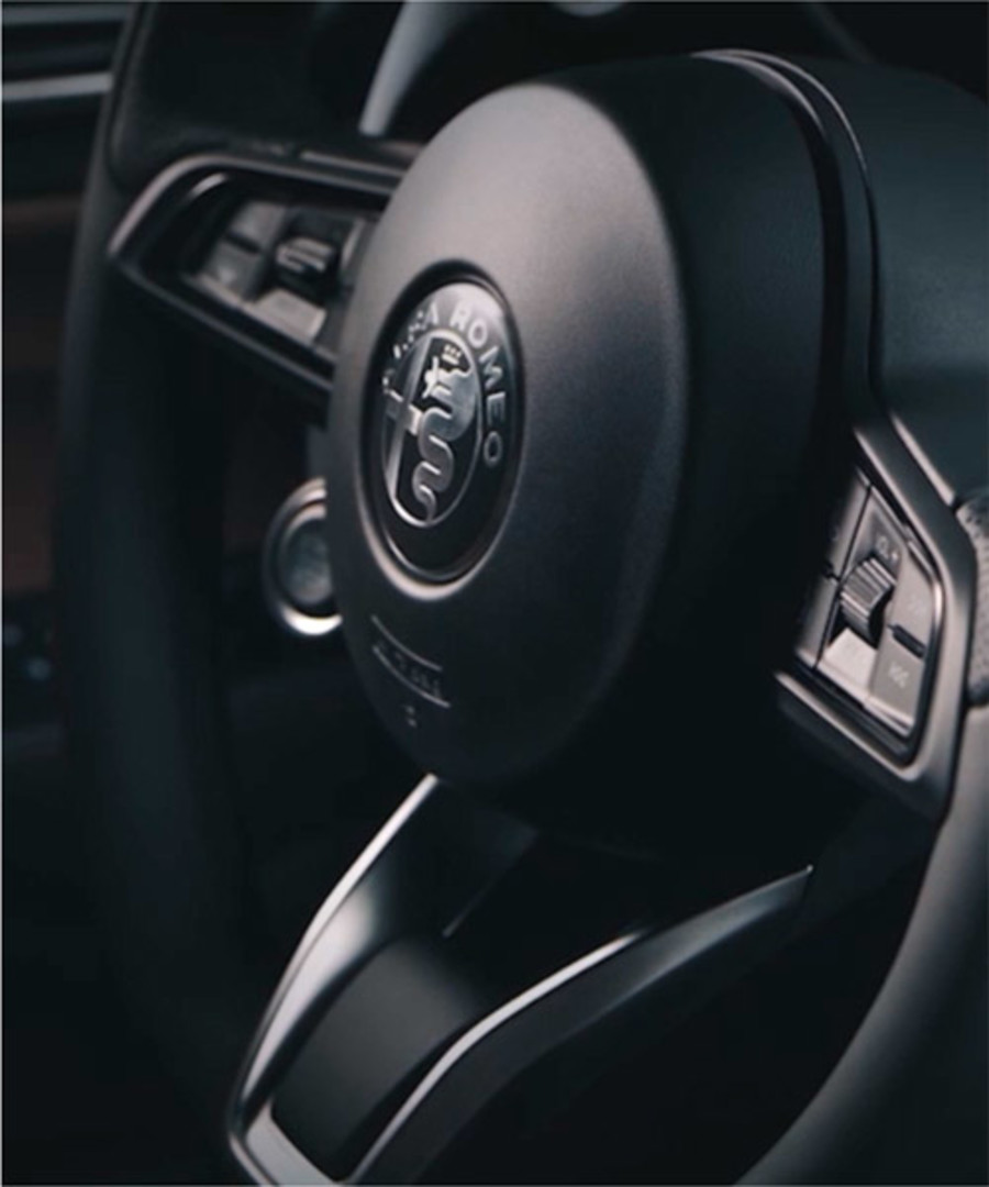 A close-up view of a 2021 Alfa Romeo Stelvio steering wheel.