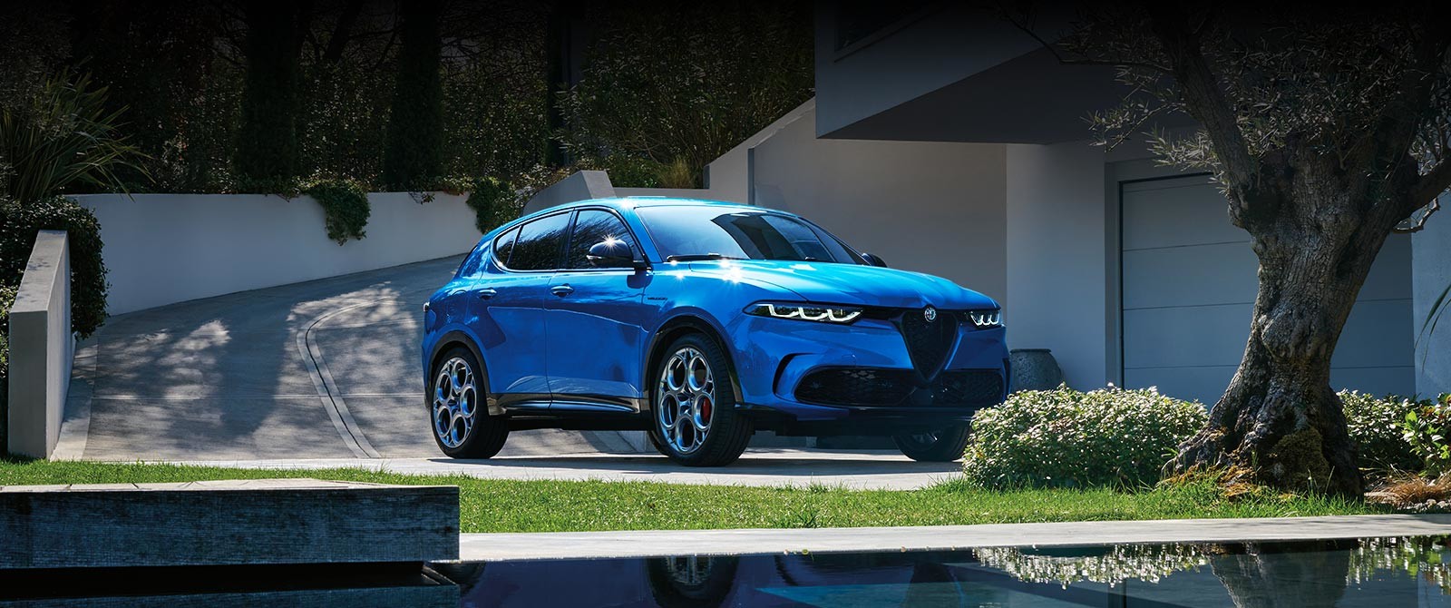 Misano Metallic Blue 2025 Alfa Romeo Tonale parked in a modern residential driveway.