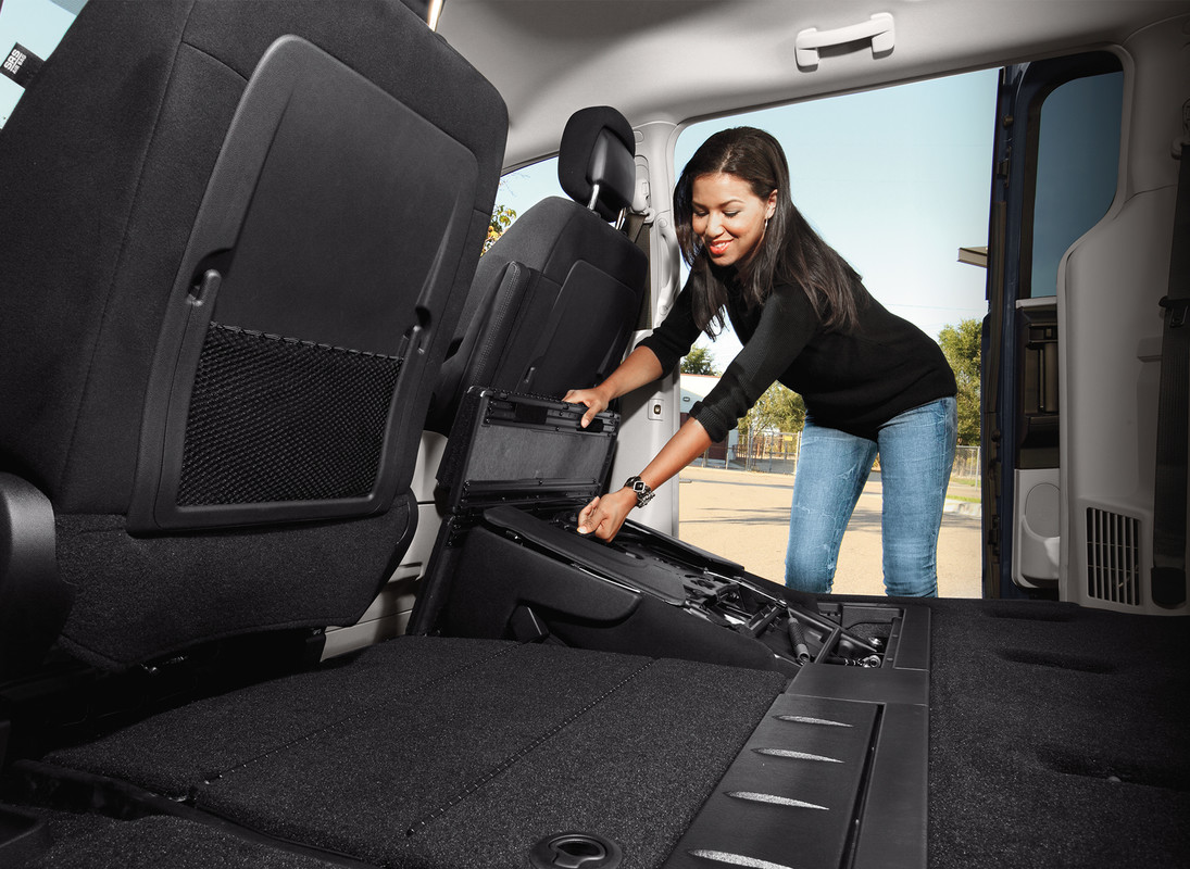 Femme repliant les sièges de deuxième rangée de la Dodge Grand Caravan 2020