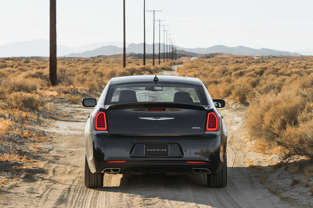 La Chrysler 300 2020 noire roulant sur un chemin de terre dans des plaines désertiques