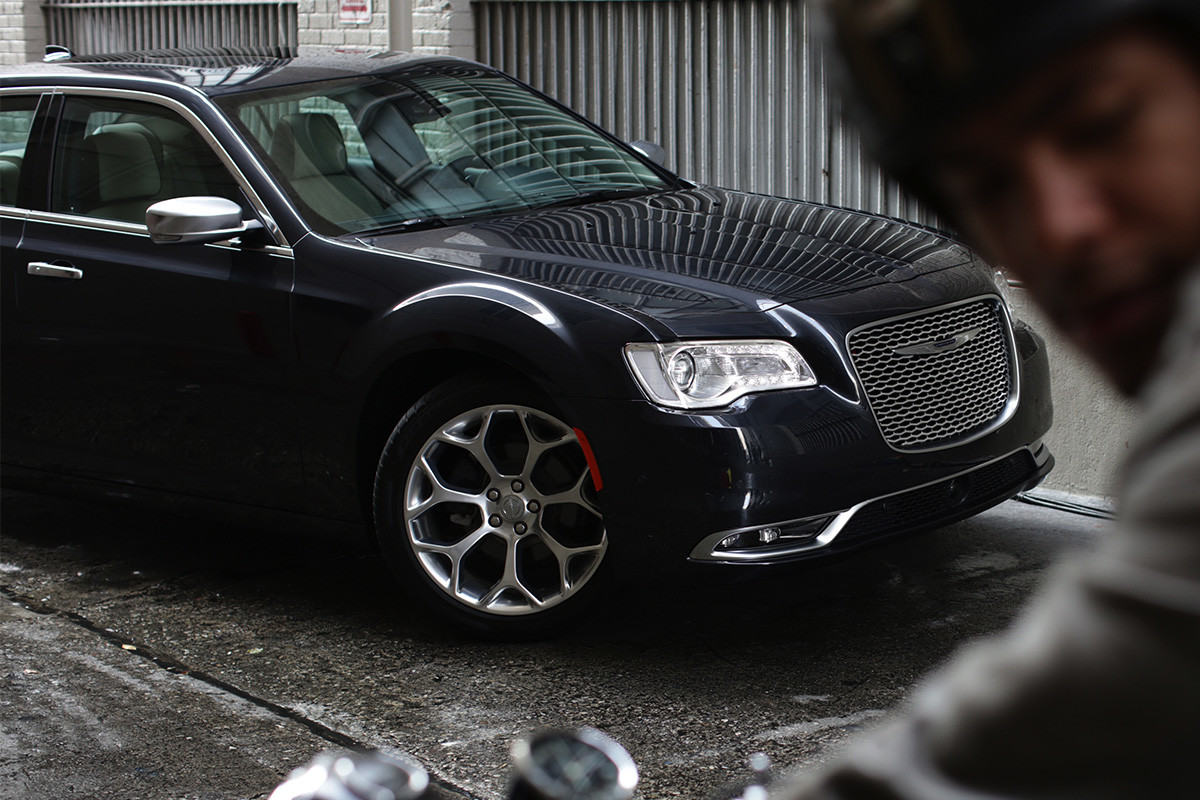 The black 2020 Chrysler 300 parked in front of building showing its wheel