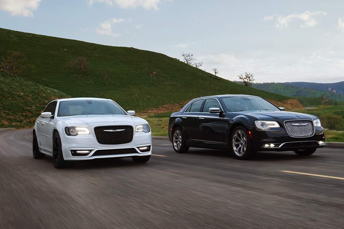 La Chrysler 300 2020, illustrée en blanc, roulant à côté d’une Chrysler 300 2020 noire sur une route de campagne