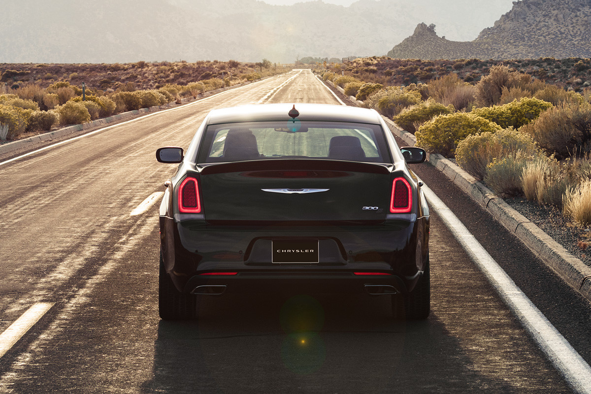 Vue arrière de la Chrysler 300 2020 noire roulant sur une route dans le désert
