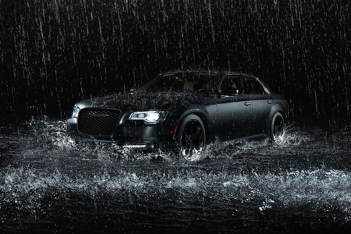Black 2021 Chrysler 300 being driven during a heavy rainfall.