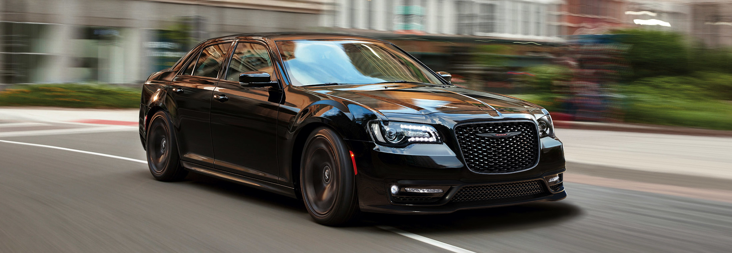 Une Chrysler 300 noire roulant dans les rues de la ville.