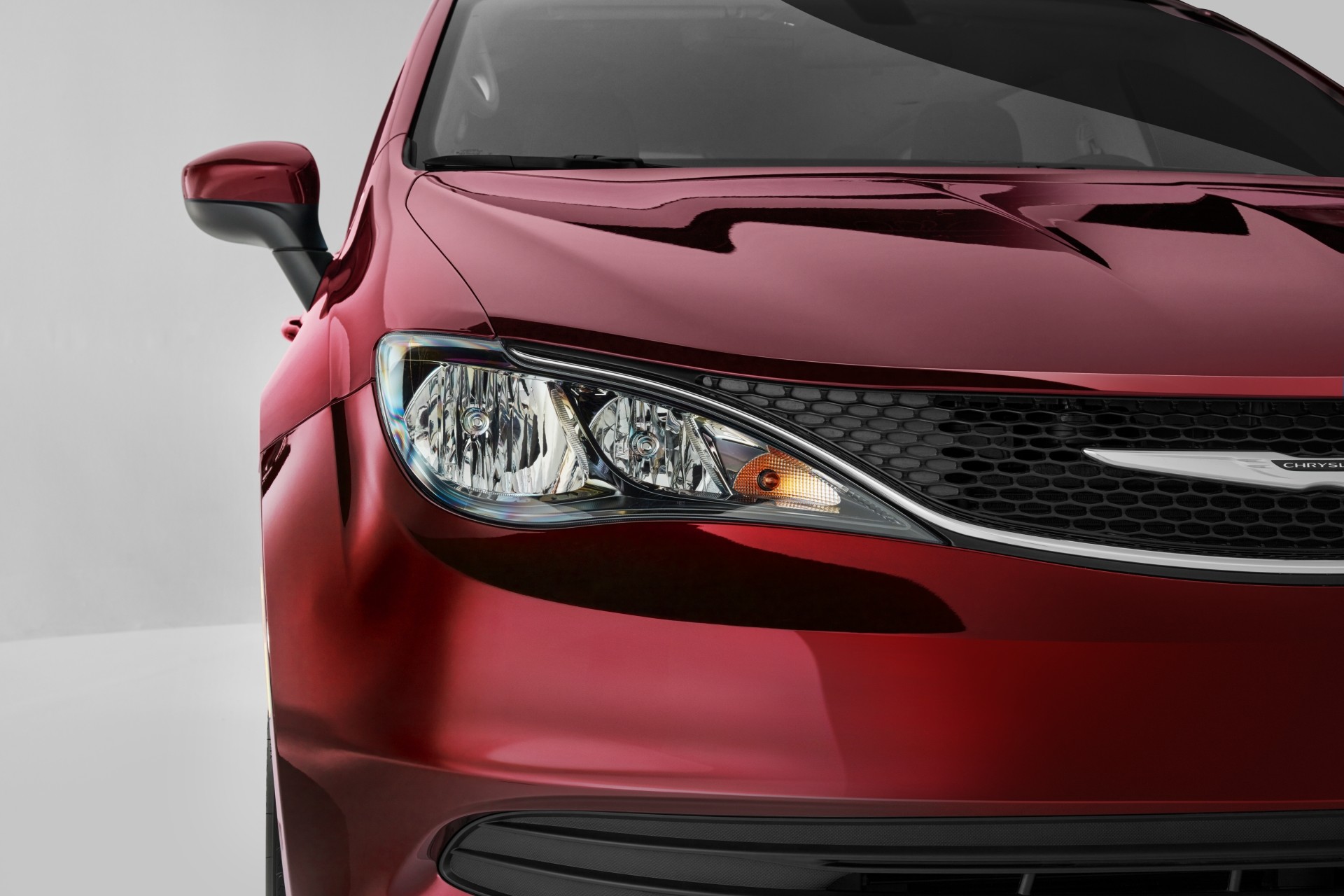 Gros plan d’une nouvelle Chrysler Grand Caravan 2021 rouge, montrant la calandre et les phares avant.