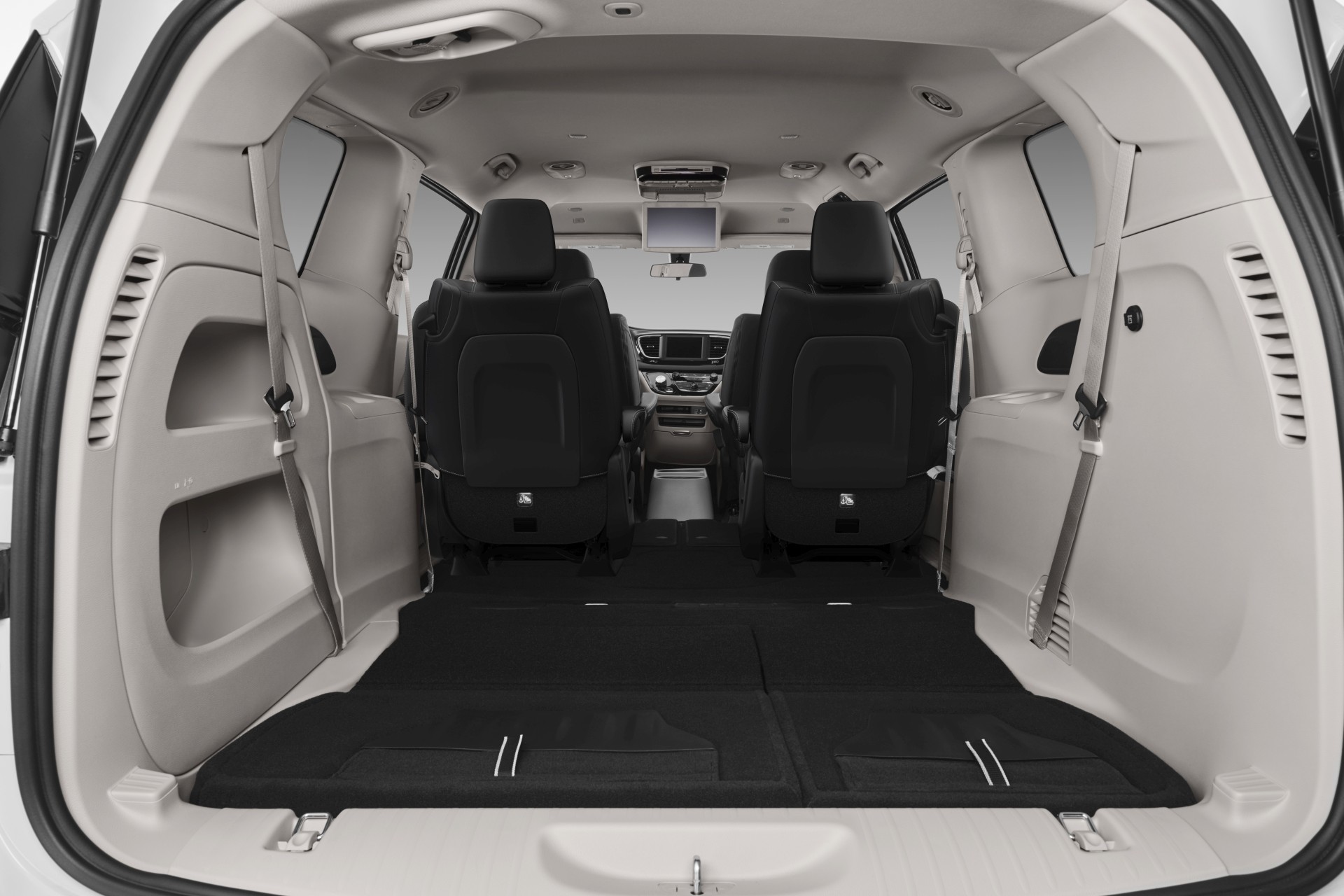 Vue arrière de l’intérieur de la nouvelle Chrysler Grand Caravan 2021. Deux sièges arrière sont repliés, laissant place à un vaste espace de rangement.