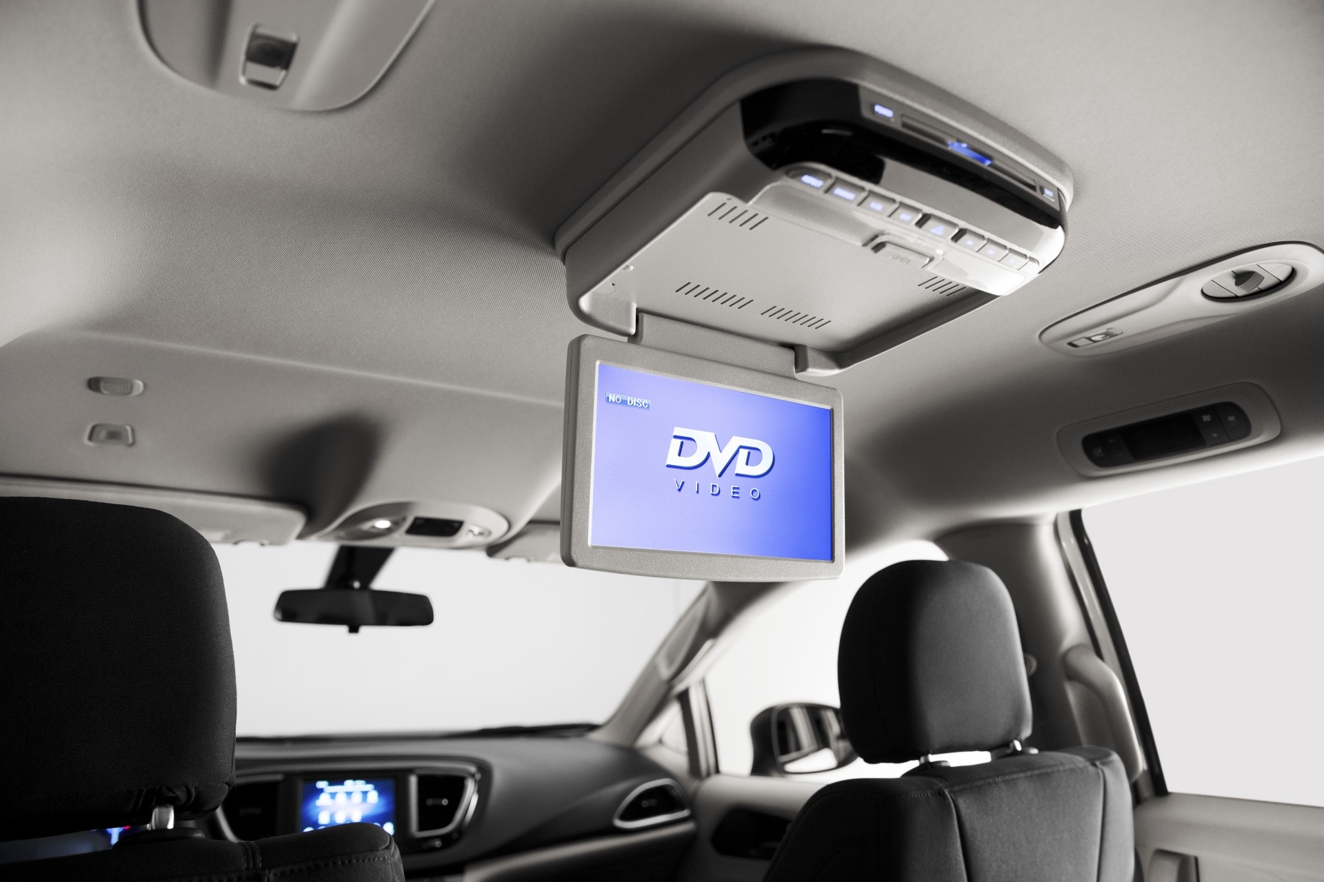 L’écran d’un lecteur DVD au pavillon simple livrable est descendu entre les deux sièges avant de la nouvelle Chrysler Grand Caravan 2021 et fait face à l’arrière.