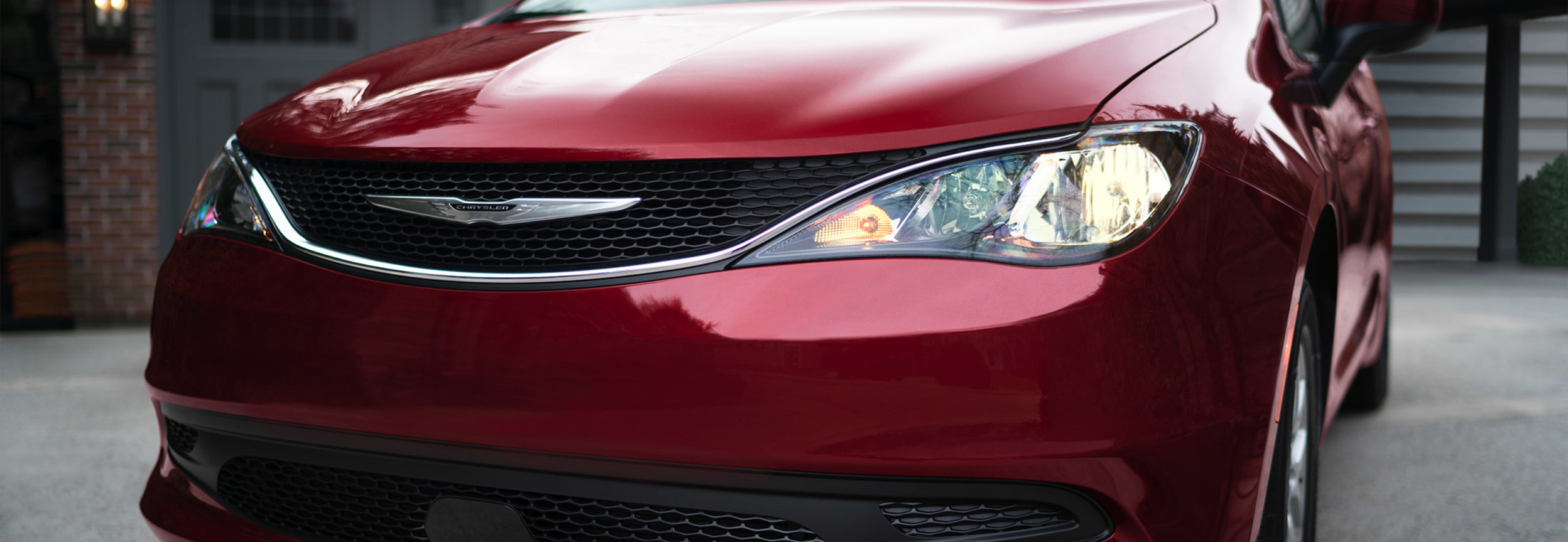 The front of a red 2022 Chrysler Grand Caravan in a driveway