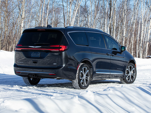 Pacifica Pinnacle AWD in Brilliant Black parked on a snowy tree-lined road