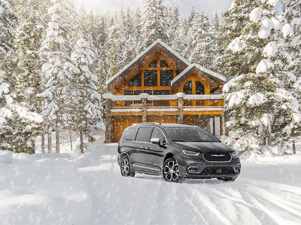View of a grey 2024 Chrysler Pacifica parked outdoors during a storm.